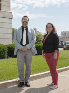Two people standing next to each other outside